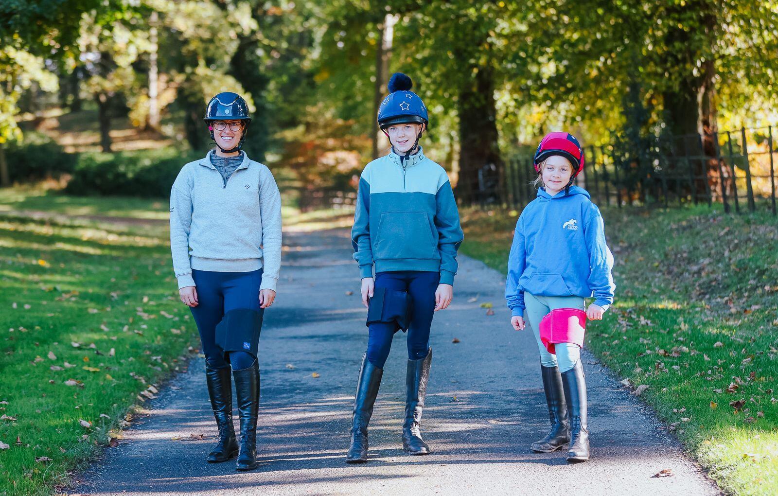 three horse riders all wearing their Equiseat Aids, the aids are in Black, French Navy & Cerise Pink