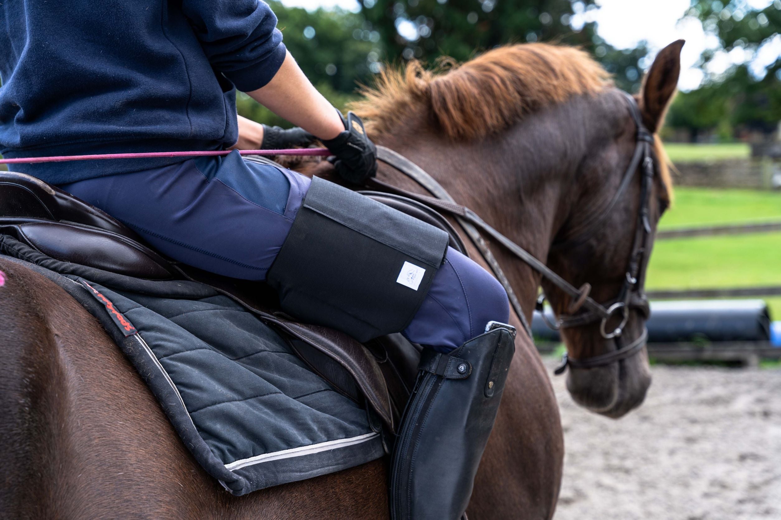 Horse rider wearing black Equiseat Aid riding liver chestnut horse