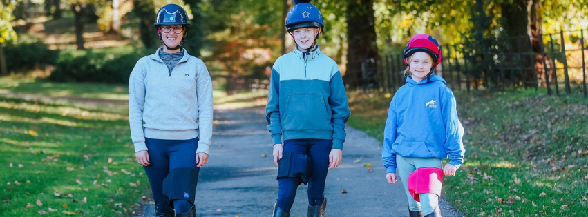 3 Horse riders all wearing their Equiseat Aid, featuring the black, French navy and cerise pink aid.