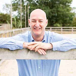 Dr David Marlin leaning against an arena fence